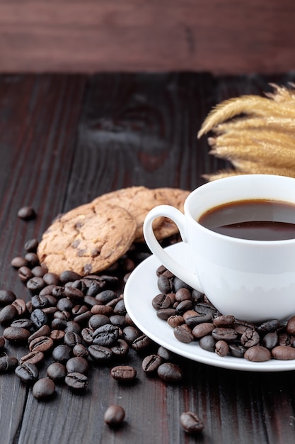 Tazza di caffè e chicchi di caffè su fondo in legno.