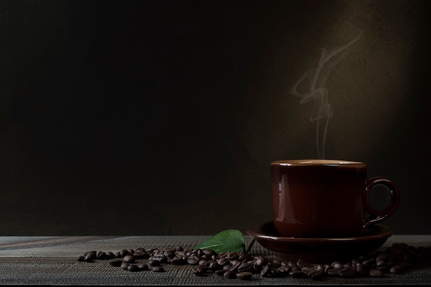 Tazza di caffè e chicchi di caffè sul tavolo. Sfondo scuro.