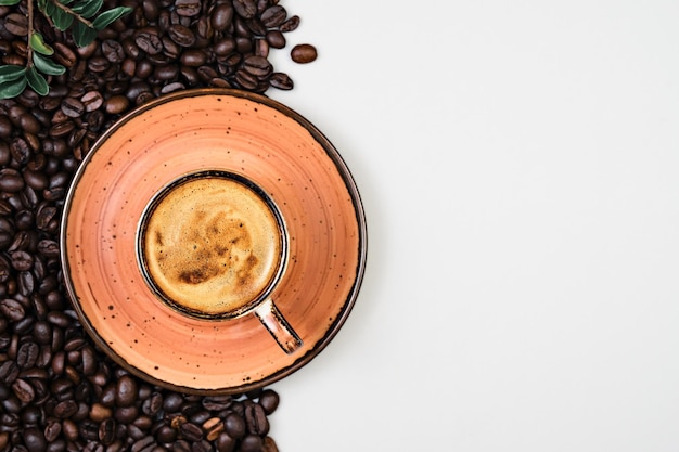 Tazza di caffè e chicchi di caffè tostati su uno sfondo grigio. Crema al caffè profumata in tazza. Tazza di caffè espresso in un caffè, modello con copia spazio per il tuo testo