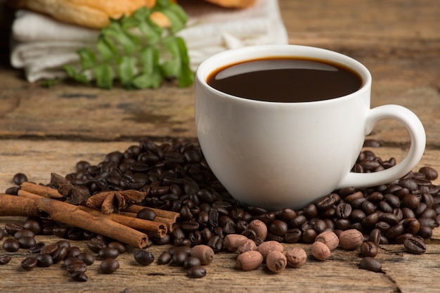 Tazza di caffè e chicco di caffè su un tavolo di legno. Sfondo scuro