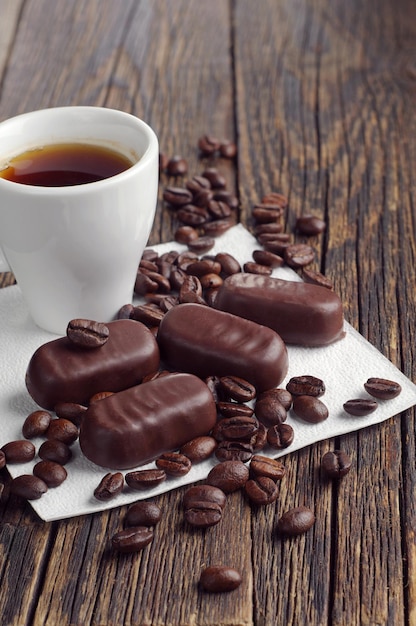 Tazza di caffè e cioccolatini sul vecchio tavolo di legno