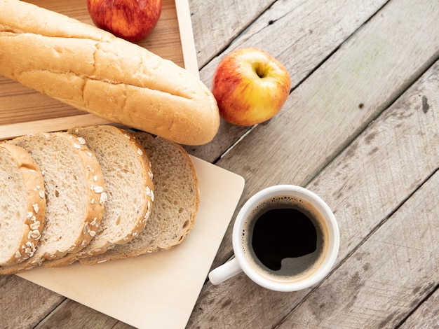 Tazza di caffè e colazione pane sul tavolo di legno