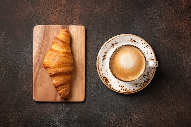 Tazza di caffè e croissant fresco