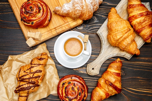 Tazza di caffè e croissant su fondo di legno