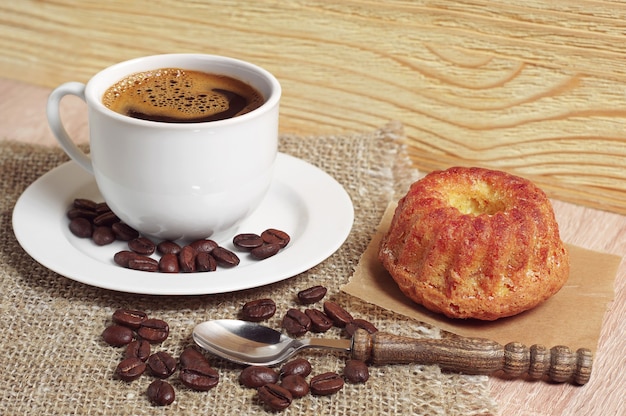 Tazza di caffè e cupcake dolce per colazione sul tavolo di legno