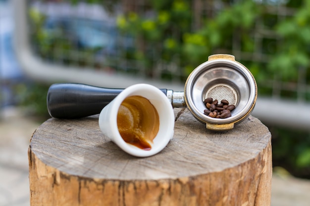 Tazza di caffè e fagioli in portafiltro per caffè espresso