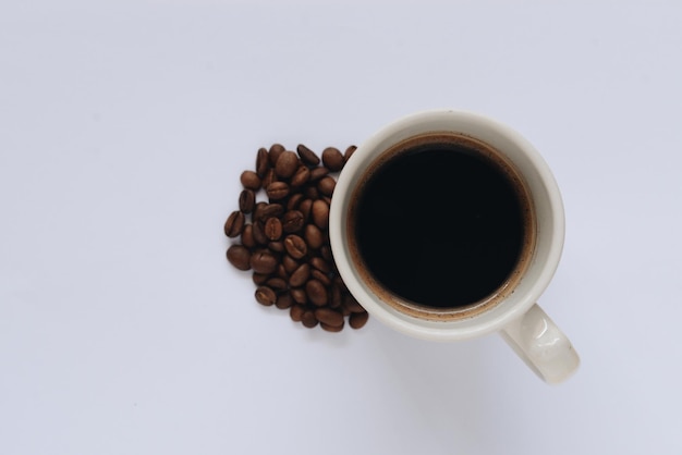 Tazza di caffè e fagioli su uno sfondo bianco