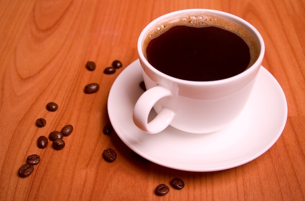 Tazza di caffè e fagioli sul tavolo di legno