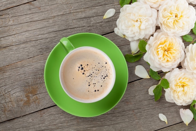 Tazza di caffè e fiori di rosa bianca