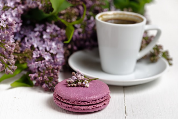 Tazza di caffè e fiori lilla colorati sul tavolo da giardino