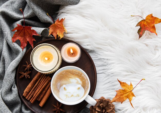 Tazza di caffè e foglie di autunno su un fondo della pelliccia