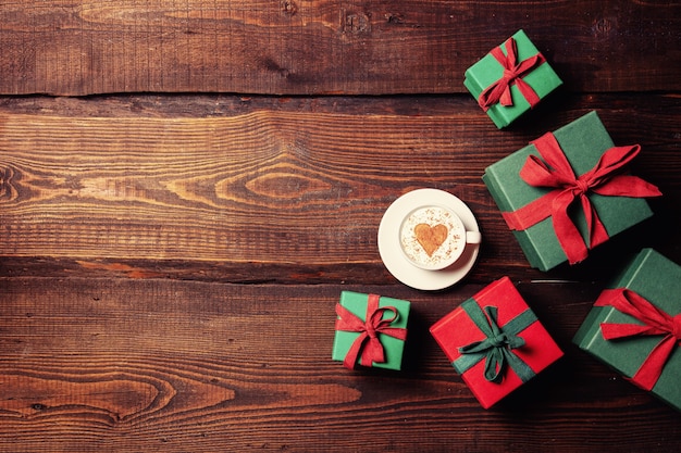 Tazza di caffè e forma di cuore accanto alla confezione regalo sul tavolo di legno. Vista dall'alto