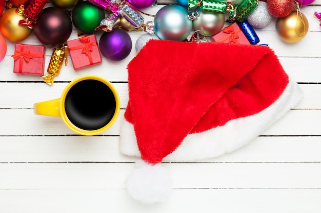 Tazza di caffè e giocattoli di Natale sul tavolo bianco.