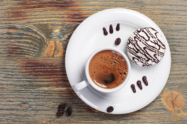 Tazza di caffè e gustosi biscotti sulla tavola di legno d'epoca