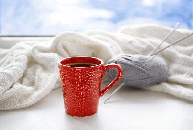 Tazza di caffè e lavoro a maglia sul davanzale
