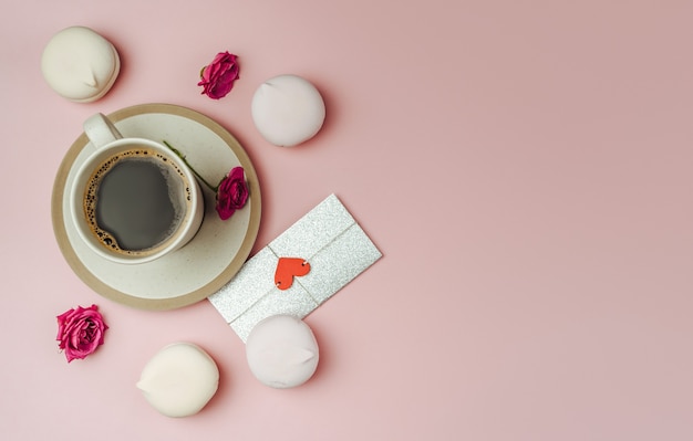 Tazza di caffè e lettera d'amore su carta rosa di tendenza