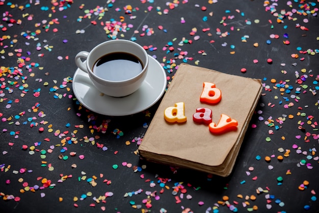 Tazza di caffè e libro con le lettere di giorno b