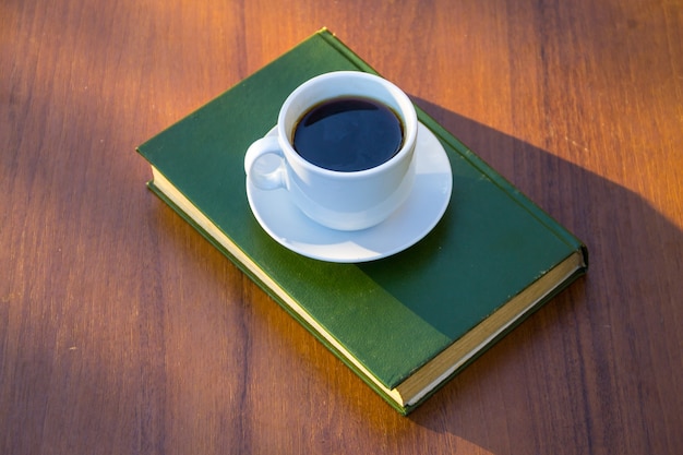 Tazza di caffè e libro sul tavolo di legno