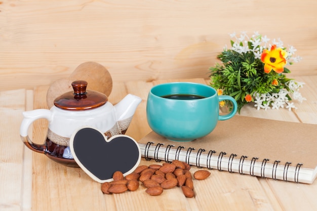 tazza di caffè e libro sul tavolo di legno.