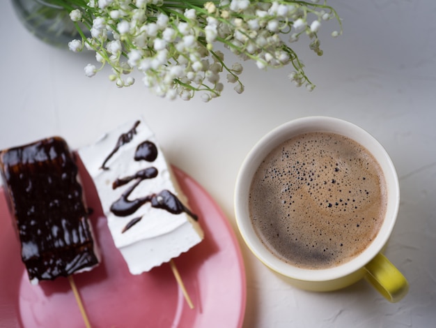 Tazza di caffè e marshmallow al cioccolato fatti in casa su un piatto