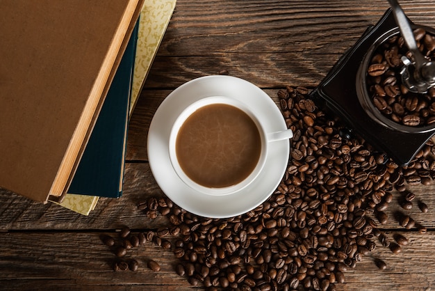 Tazza di caffè e mucchio di fagioli su un tavolo di legno