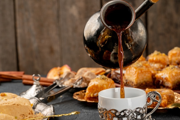 Tazza di caffè e pasticcini turchi sulla superficie scura si chiuda