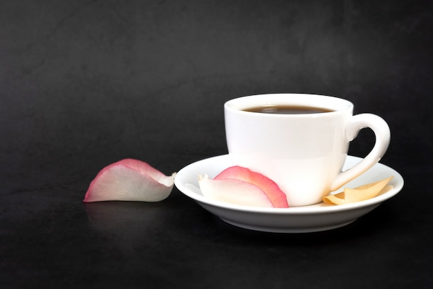 Tazza di caffè e petali di rosa.