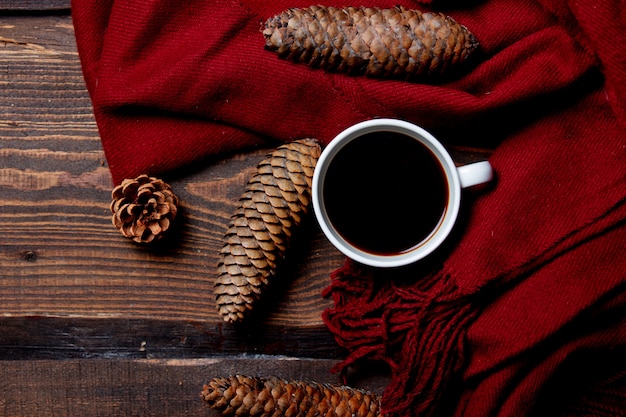 Tazza di caffè e sciarpa sulla tavola di legno