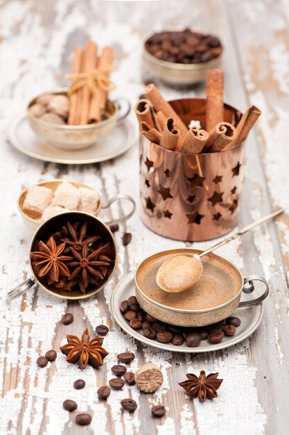 Tazza di caffè e spezie in tazza d'argento vintage su sfondo di legno