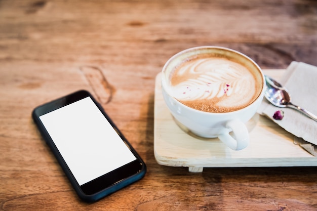 tazza di caffè e telefono cellulare sul tavolo