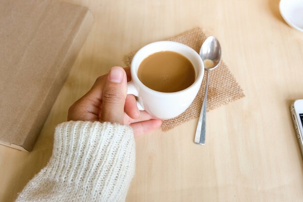 Tazza di caffè e un libro sul tavolo in legno in natura sfondo,