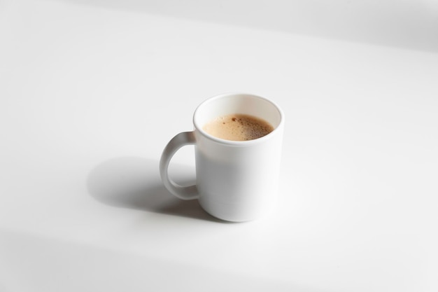 Tazza di caffè espresso crema fresco con bolla e schiuma su sfondo o tavolo vuoto bianco