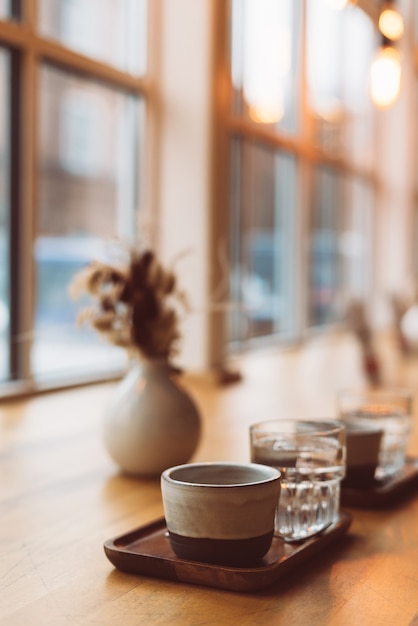 Tazza di caffè espresso e bicchiere d'acqua sulla tavola di legno