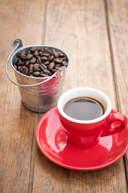 Tazza di caffè espresso rossa sulla tavola di legno