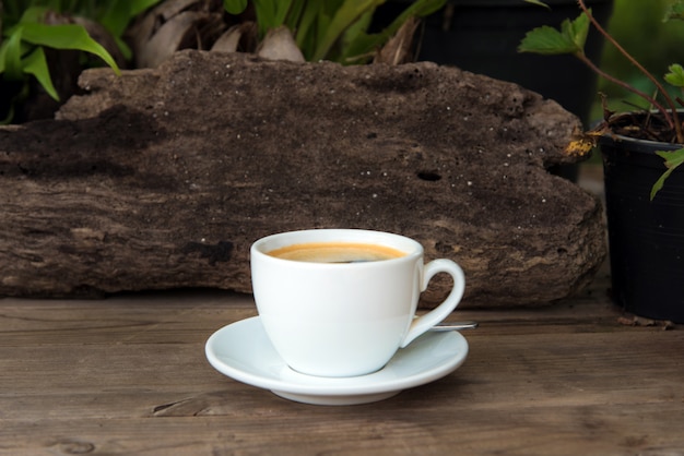 Tazza di caffè fresco con chicchi di caffè sul tavolo di legno
