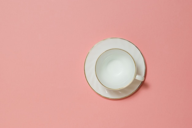 Tazza di caffè in ceramica bianca su sfondo rosa. Piatti per bevande calde.