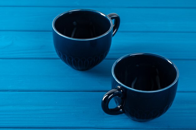 Tazza di caffè in ceramica blu scuro sul tavolo. Concetto di stoviglie