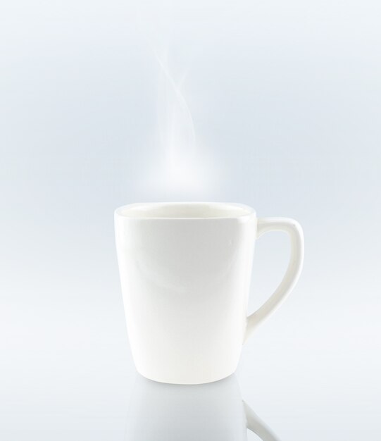 Tazza di caffè in ceramica su sfondo grigio con fumo bianco