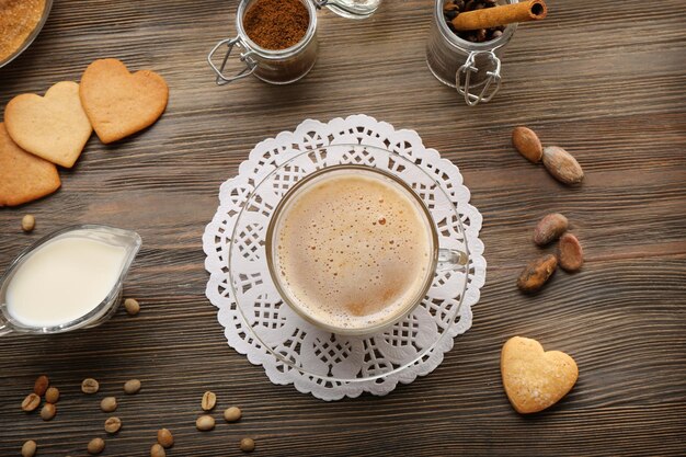 Tazza di caffè in vetro con latte su sfondo di legno