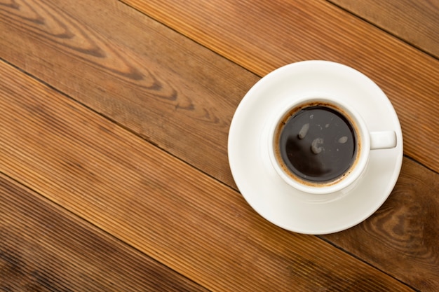 Tazza di caffè isolata sulla tavola di legno. Vista dall'alto, bevanda di caffè piatto con spazio di copia.