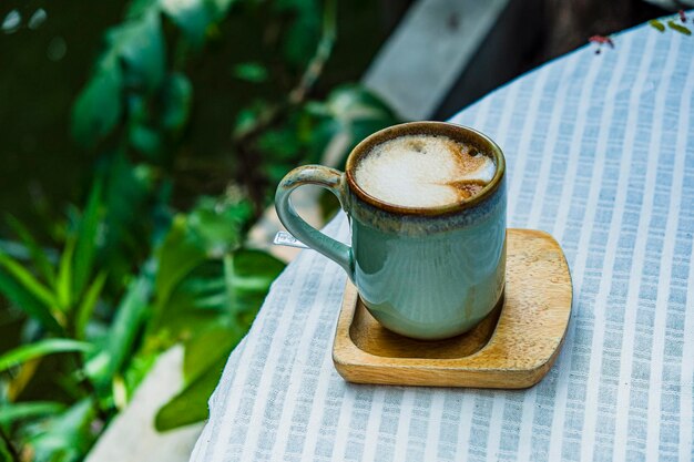 Tazza di caffè latte a forma di cuore su sfondo di legno vecchio alla luce del sole del mattino