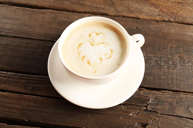 Tazza di caffè latte art su sfondo di legno