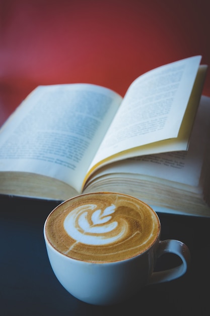 Tazza di caffè latte o cappuccino con un libro in caffetteria