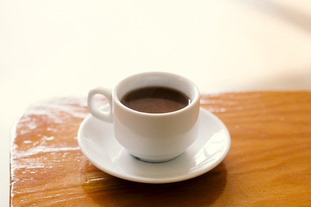 Tazza di caffè macchiato del fuoco molle su un&#39;annata della luce di mattina naturale di legno della tavola tonificata