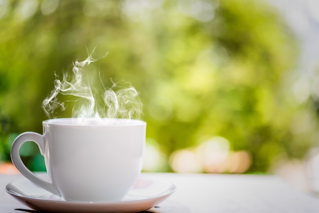 Tazza di caffè macchiato sulla tavola di legno superiore con fondo vago