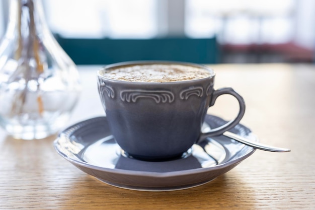 Tazza di caffè mattutina sullo sfondo della finestra in controluce della luce solare naturale Caffè cappuccino in una bella tazza