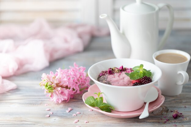 Tazza di caffè, muesli con fragole, noci e latte.