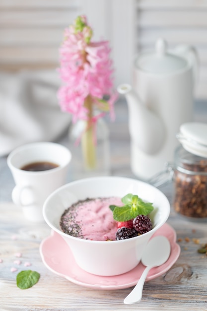 Tazza di caffè, muesli con fragole, noci e latte.