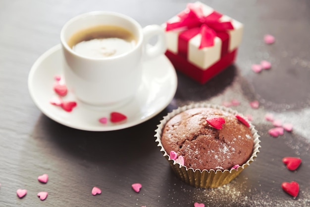 Tazza di caffè muffin al cioccolato e regalo Luce solare messa a fuoco selettiva vintage Il concetto di un romantico compleanno mattutino o San Valentino