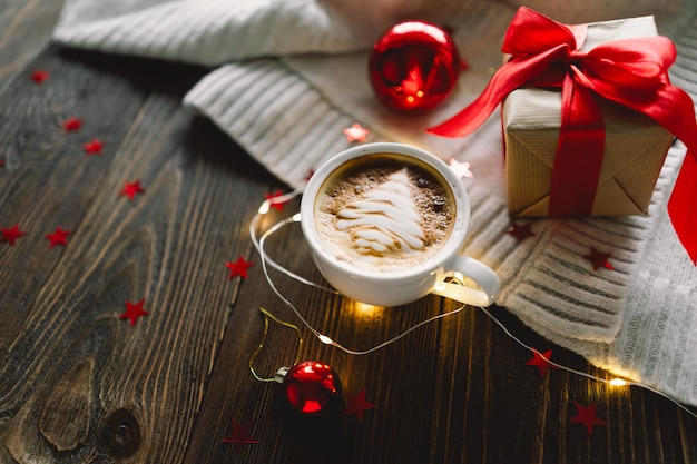 Tazza di caffè natalizia con maglione e decorazioni natalizie